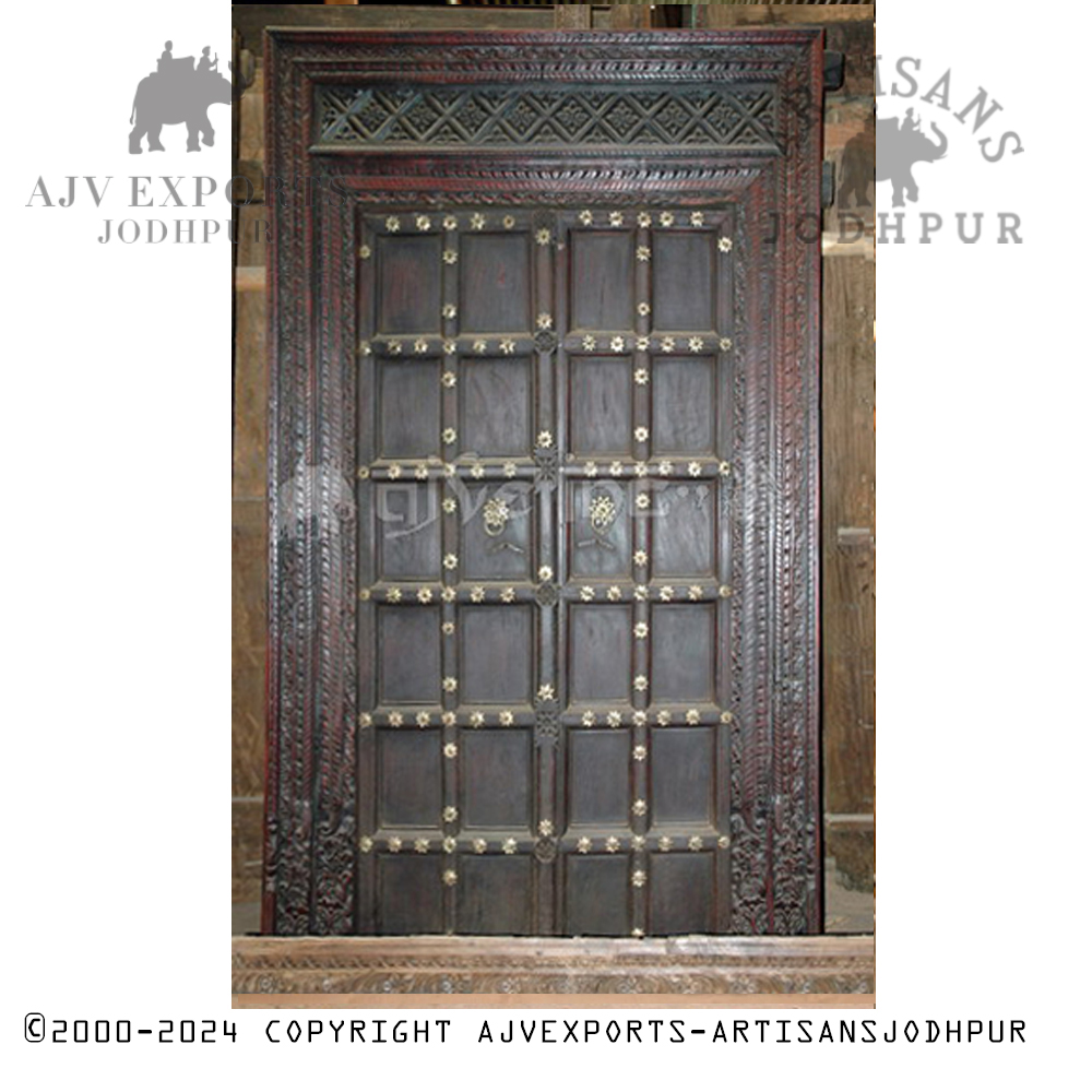 Dark antique wooden door with brass embellishments