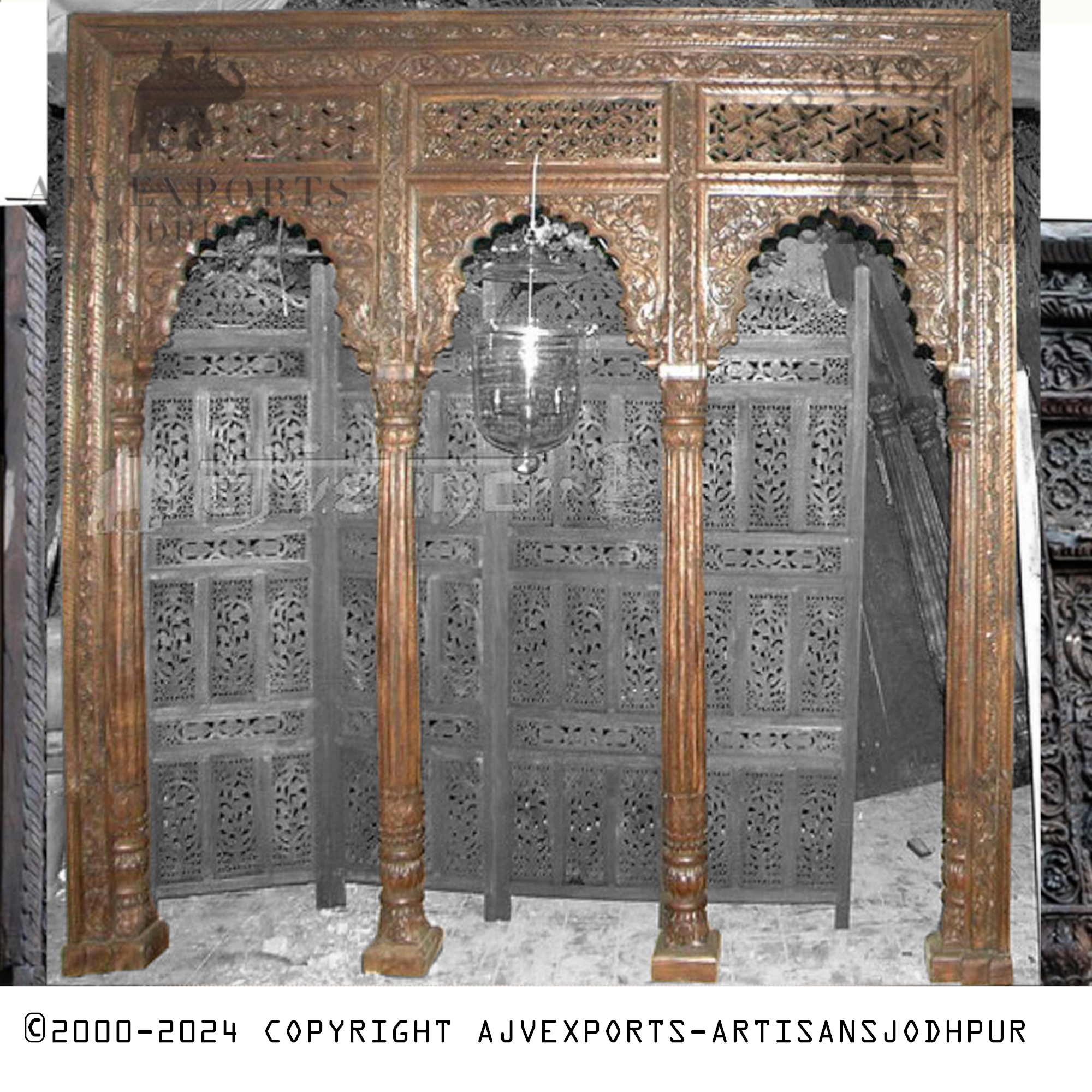 A lavishly carved Indian archway from Jodhpur, adorned with intricate details including floral motifs and geometric patterns.