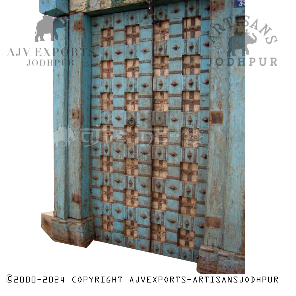 Old blue wooden door with metal studs arranged in a checkerboard pattern