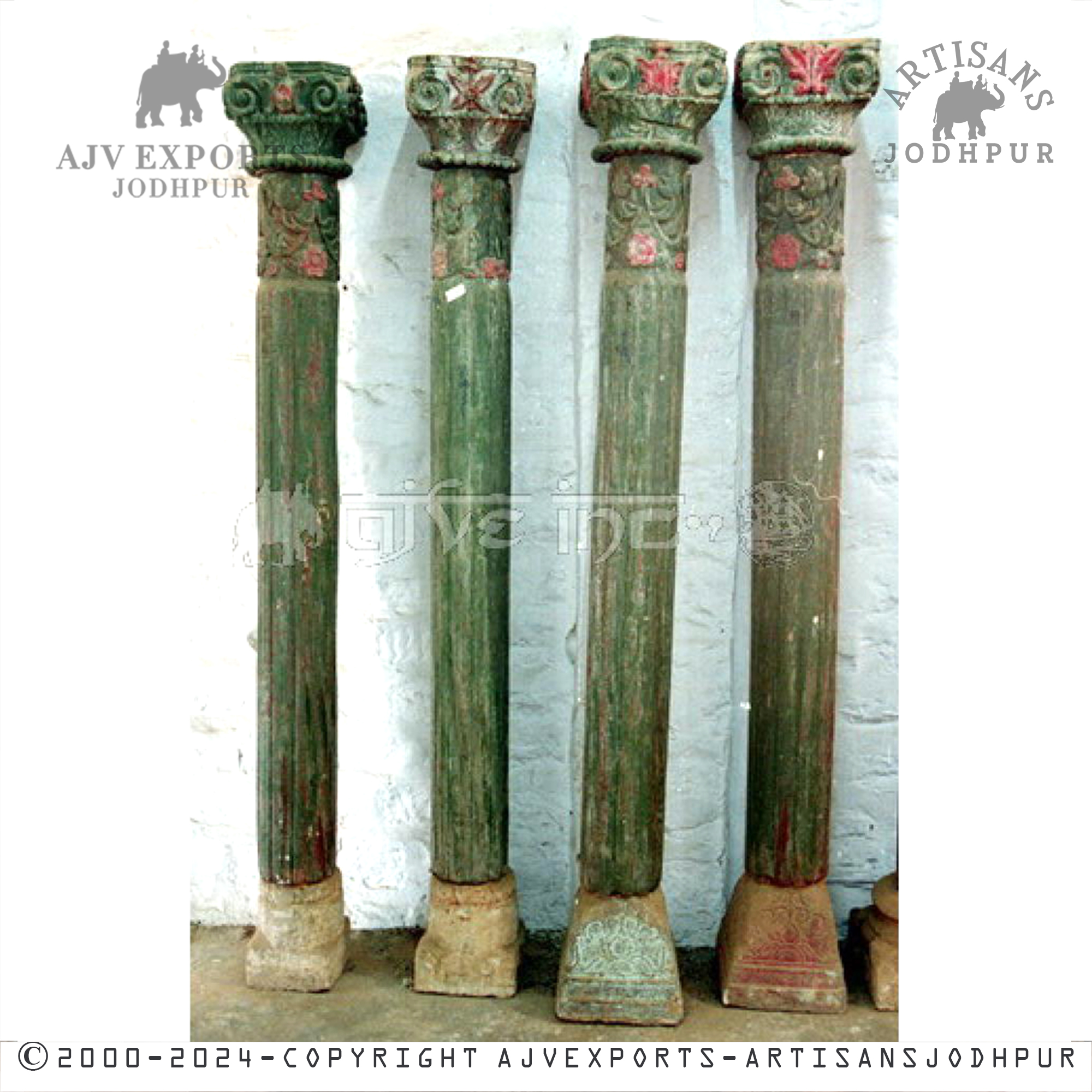 Four tall, antique wooden columns painted in green with red floral designs and ornate tops, displayed against a white backdrop