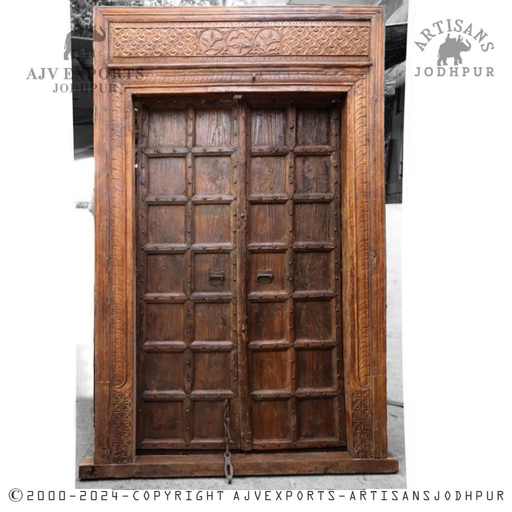 Classic wooden door with ornate carved frame and heavy bolts