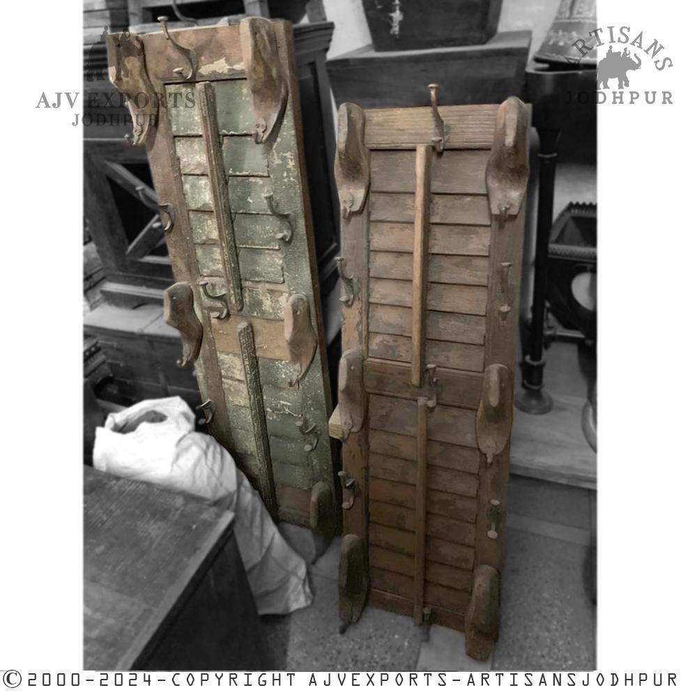 An antique wooden shutter with metal hooks, blending traditional Indian craftsmanship with practical design.