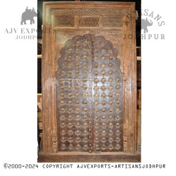 Wooden door with traditional carvings and arch