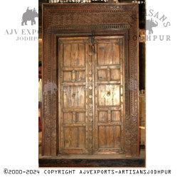 Wooden door with intricate carvings and brass