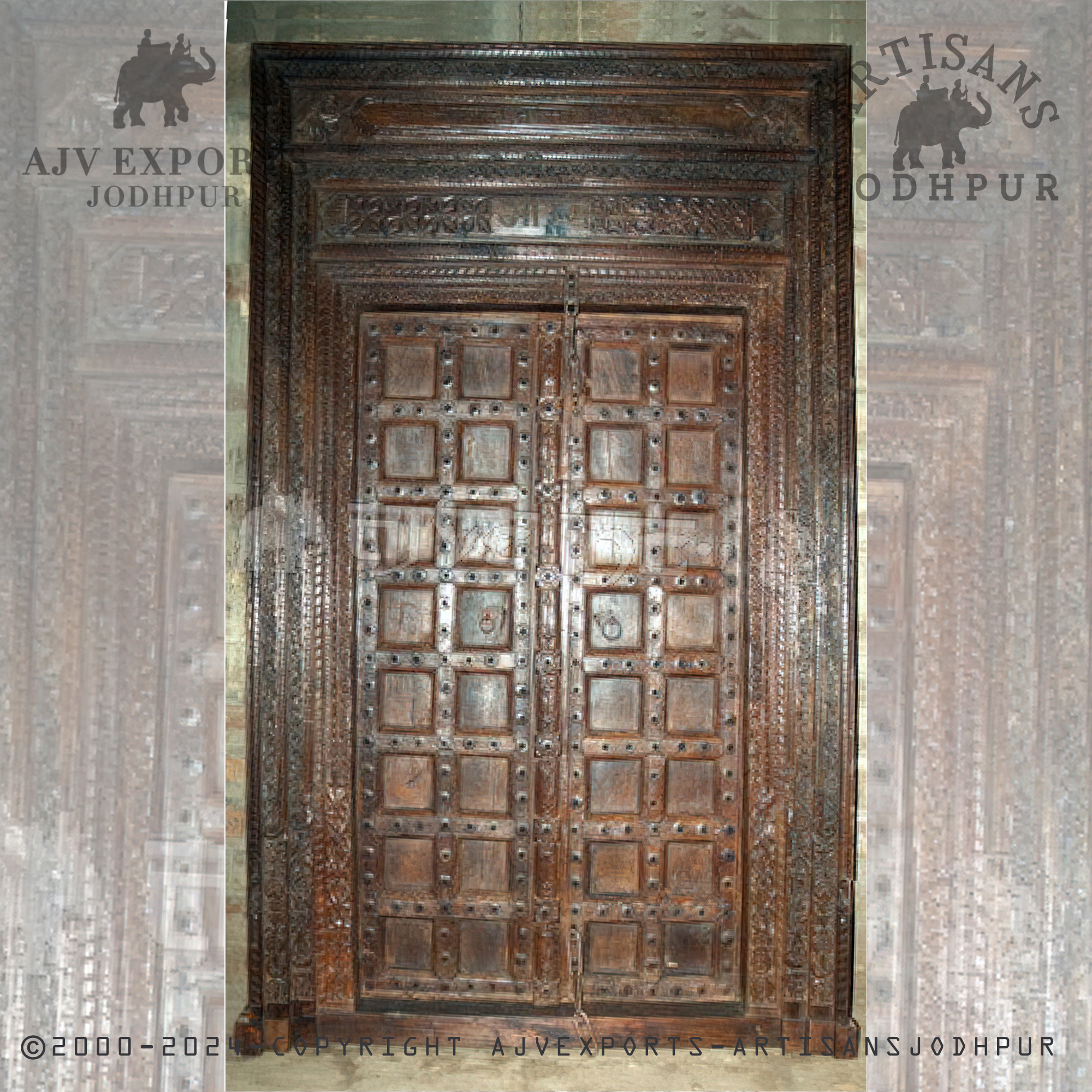 A sturdy antique wooden door with metal studs and embellishments, emphasizing a rustic charm from Jodhpur, India.