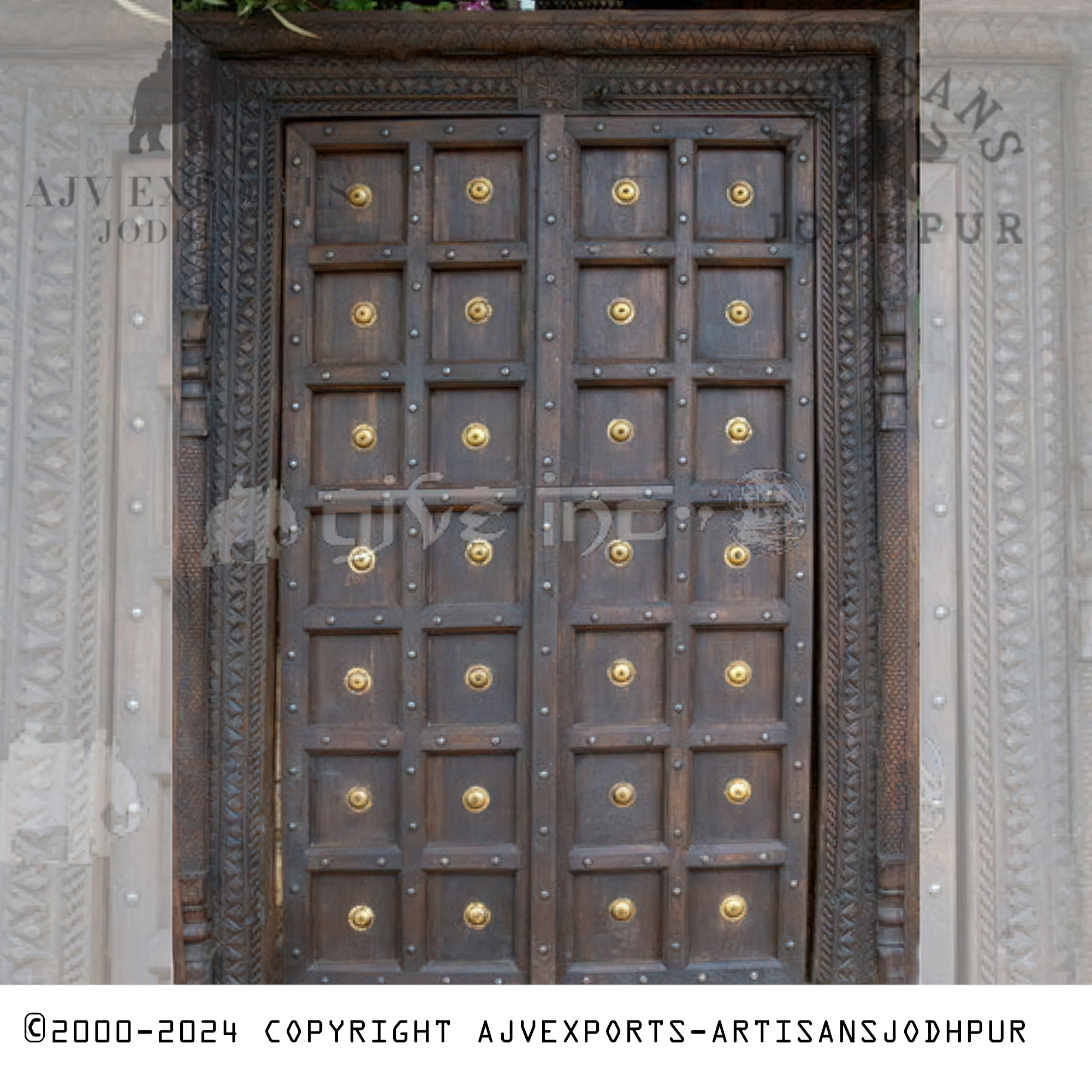 An elegant wooden door from Jodhpur, decorated with golden studs on sturdy panels, reflecting traditional Indian craftsmanship.