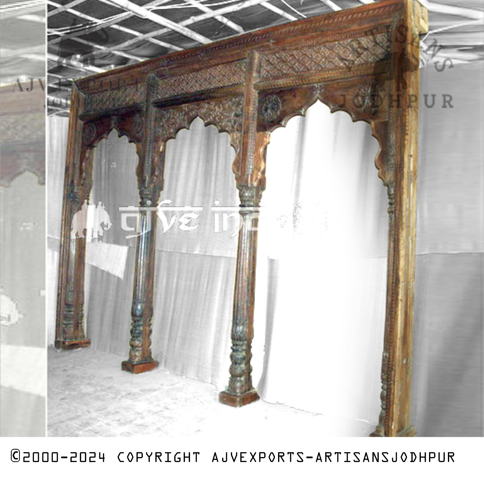 A traditional Indian archway from Jodhpur with detailed carvings on its columns and crossbeams, creating a majestic and artistic entrance.