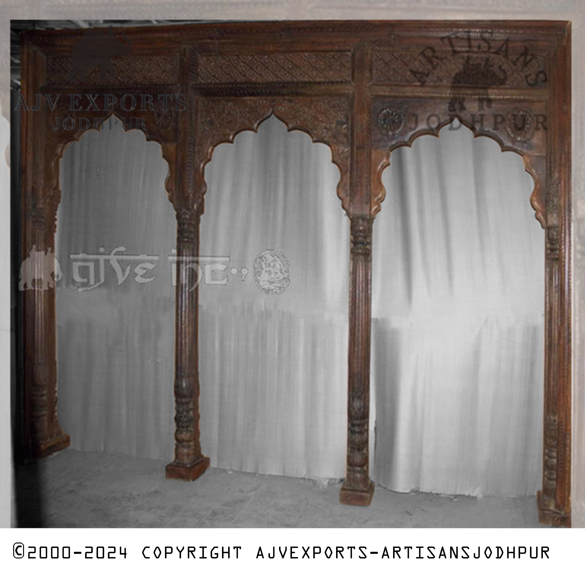 An ornately carved wooden archway from Jodhpur, featuring beautifully detailed pillars, representing the skilled craftsmanship of the region.