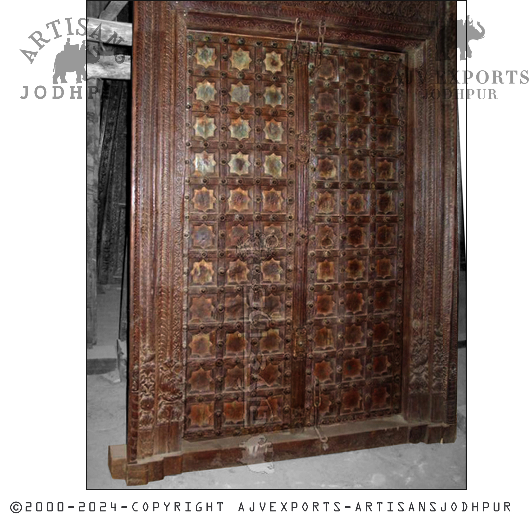 An ornate antique wooden door with star-shaped and floral patterns, showcasing Jodhpur's skilled craftsmanship.