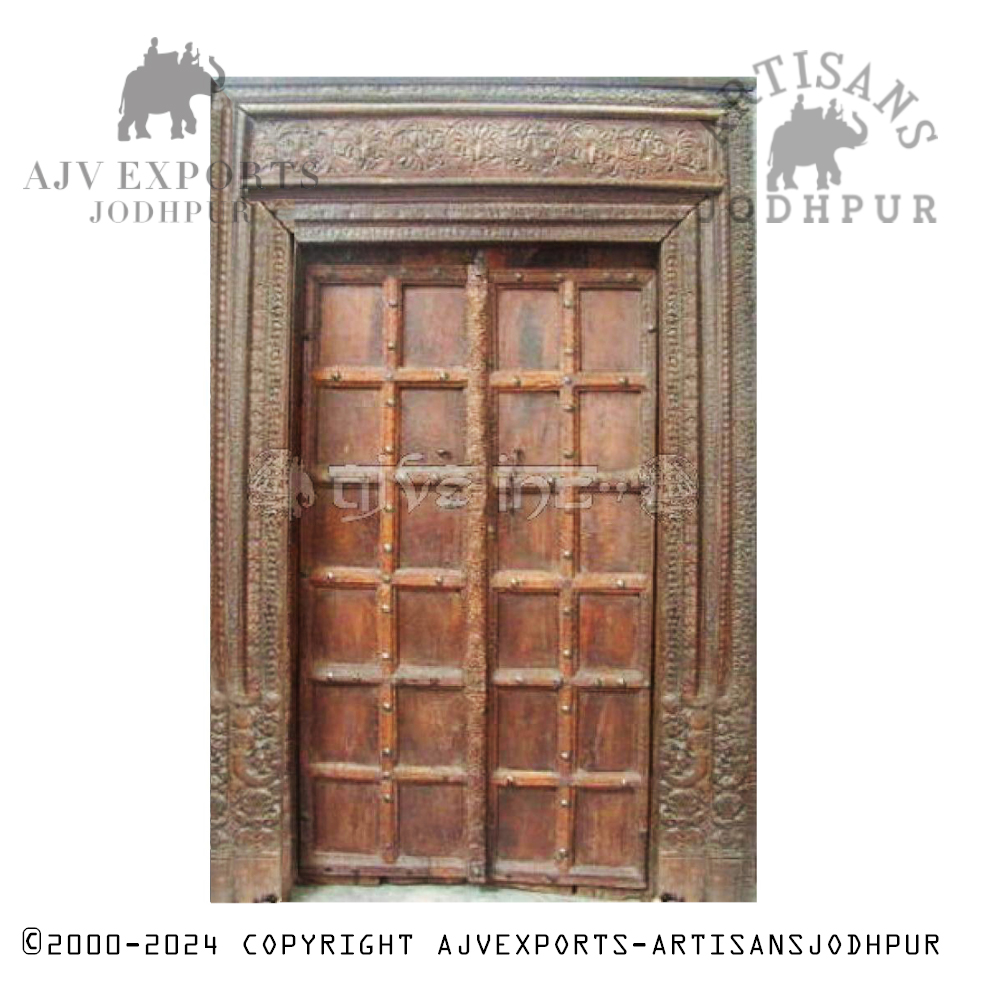 A traditional wooden door with an ornate carved frame, highlighting the intricate craftsmanship of Jodhpur artisans.