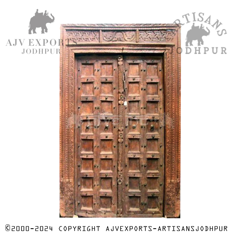 An antique wooden door with intricate carvings and detailed geometric patterns, showcasing Jodhpur's skilled craftsmanship.