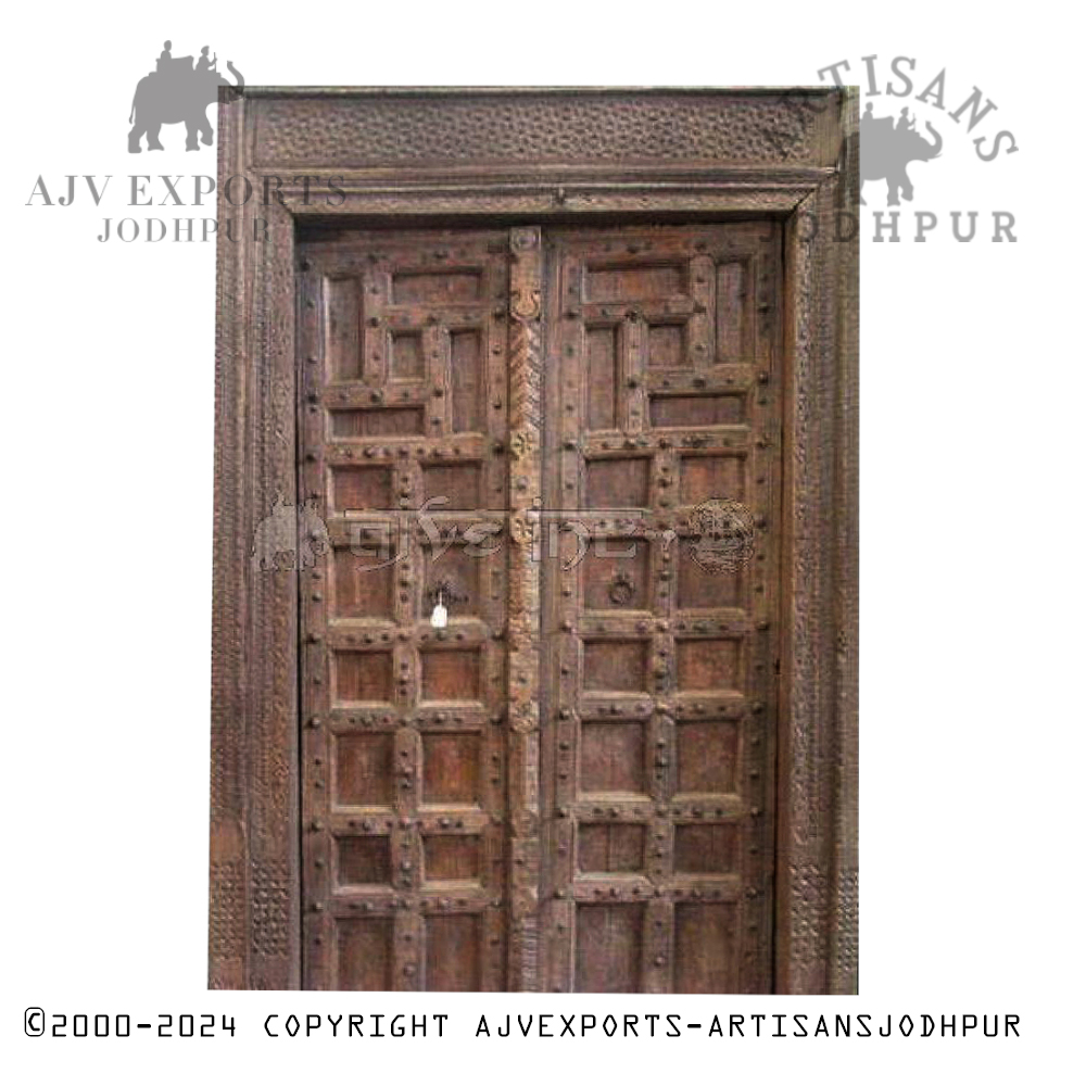 A traditional Indian wooden door with detailed carvings and an ornate design, showcasing Jodhpur's skilled craftsmanship.