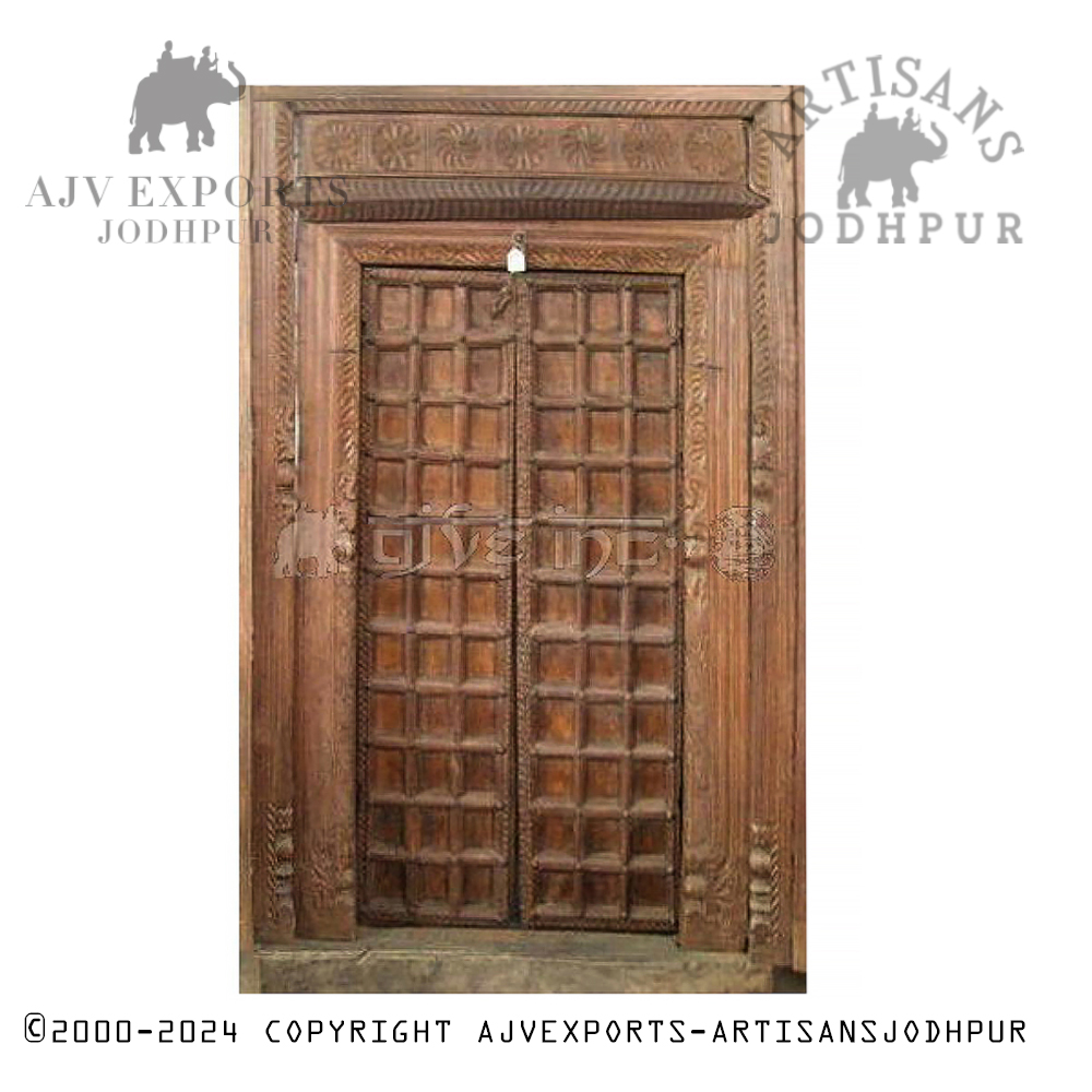 An ornate antique wooden doorway with intricate carvings and traditional designs, showcasing Jodhpur's craftsmanship.