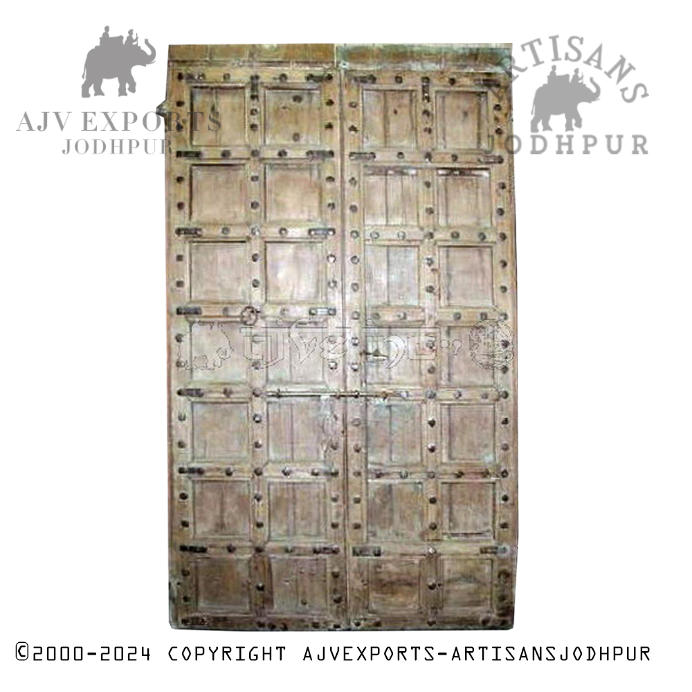 A decorative wooden door with intricate carvings and ornate design, showcasing the skilled craftsmanship of Jodhpur artisans.