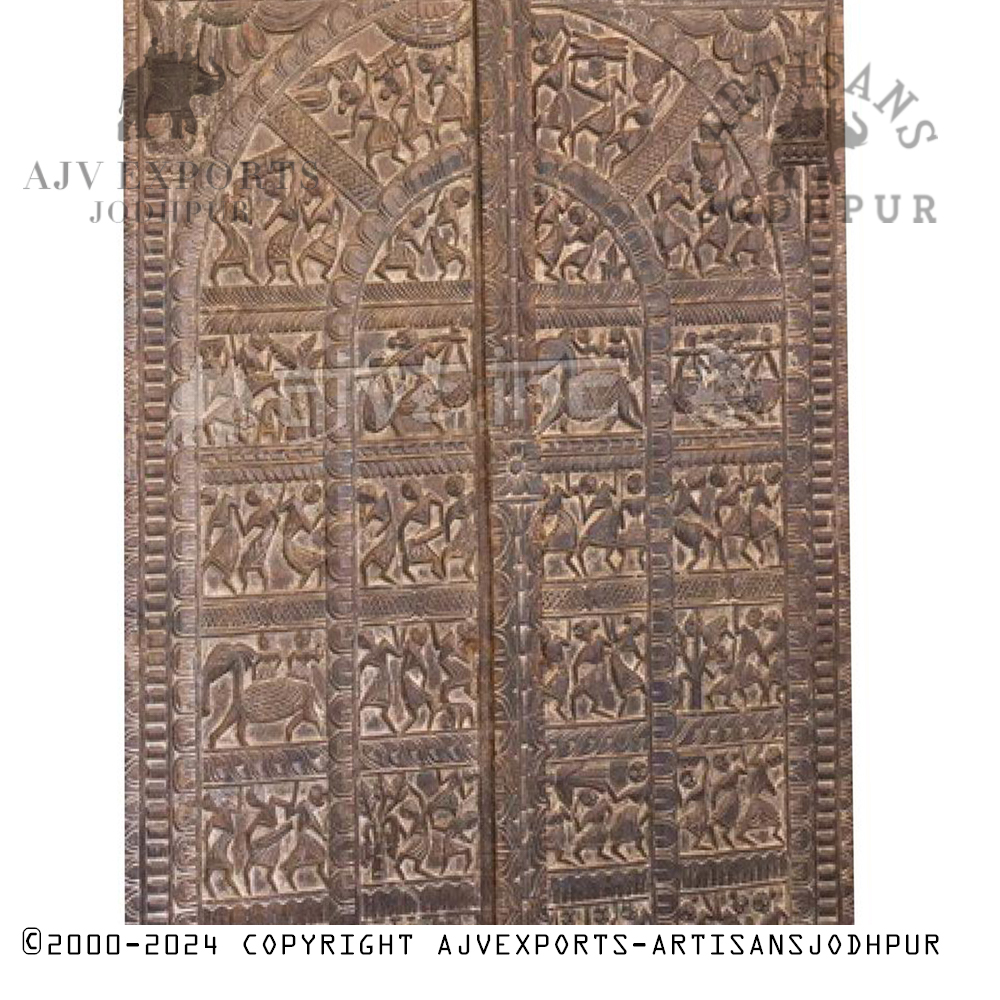 An ornate antique wooden door with tribal carving and intricate patterns, highlighting Jodhpur's craftsmanship.