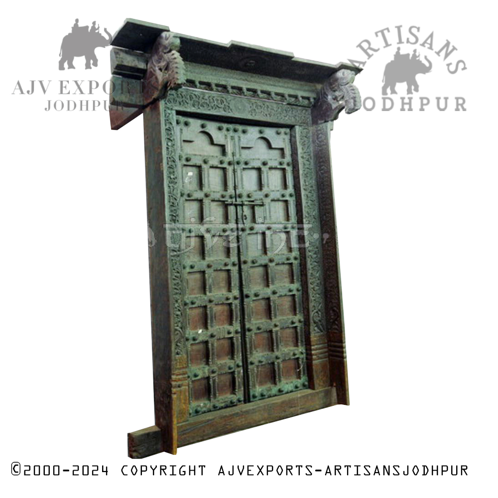 An elaborately carved wooden doorway with brass detailing and intricate patterns, highlighting Jodhpur's craftsmanship.