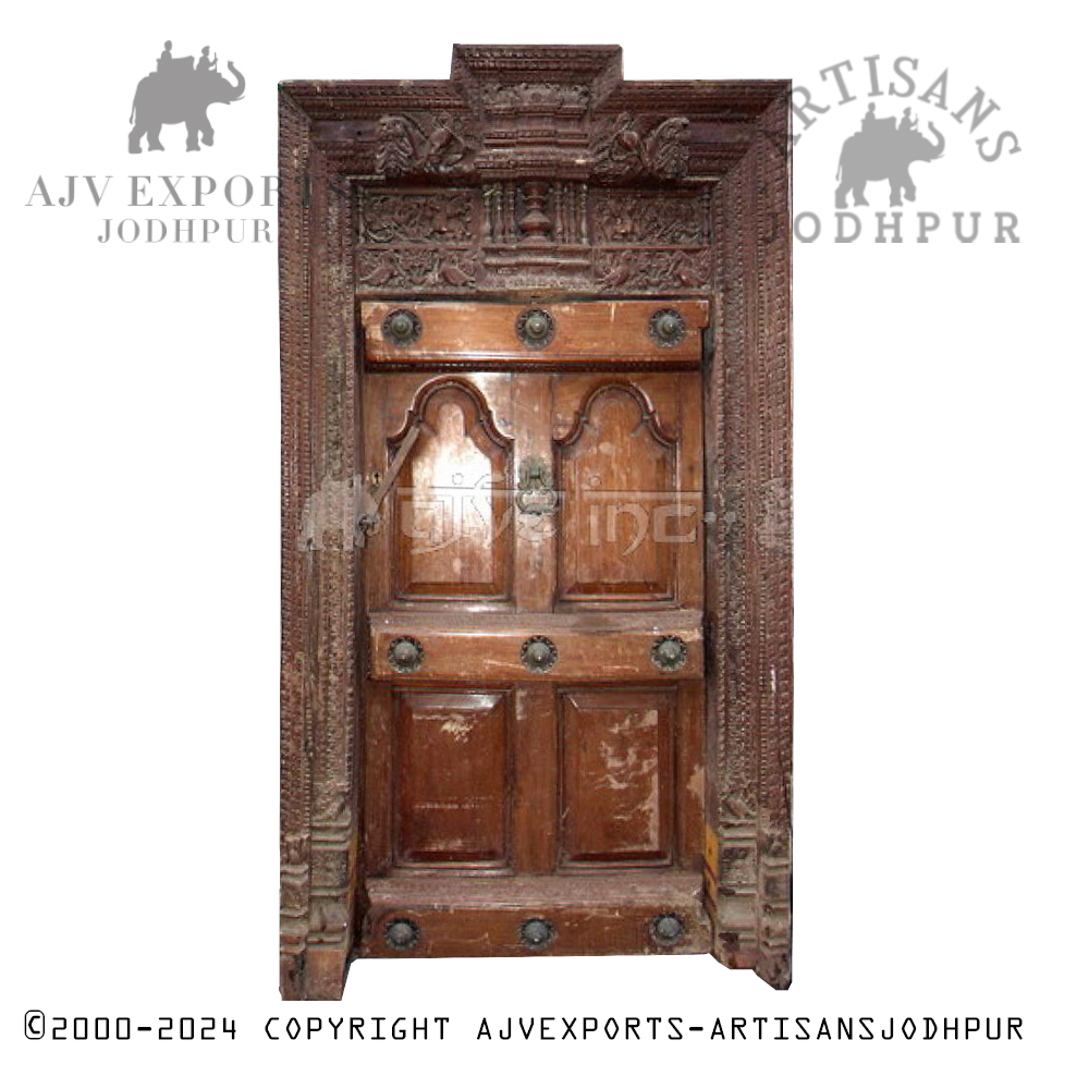 A traditional wooden door with brass embellishments and intricate carvings.
