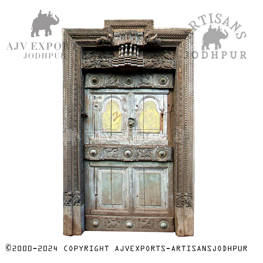 A vintage carved wooden door with brass accents, reflecting traditional Indian design