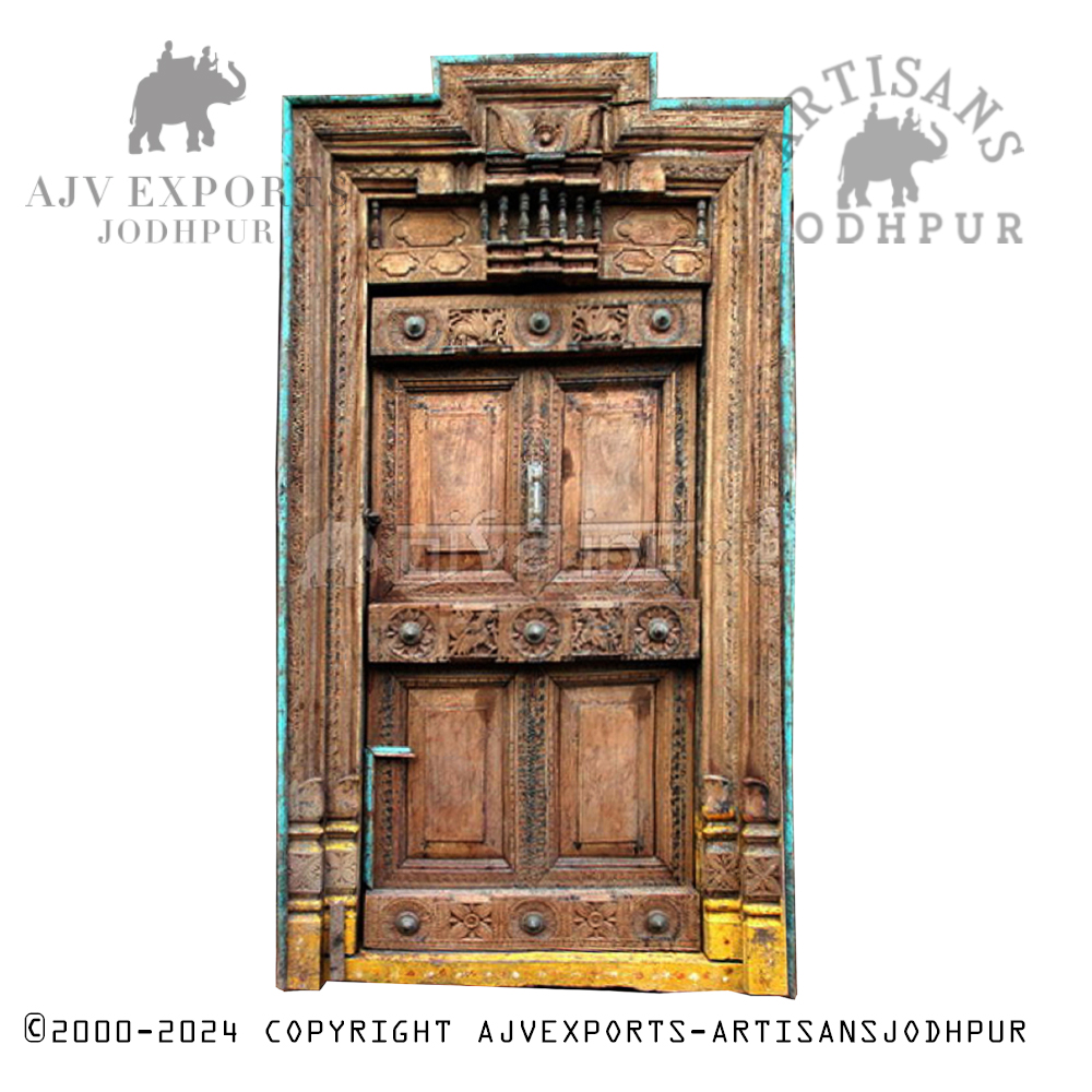 An antique Indian door with ornate metalwork and traditional carvings.