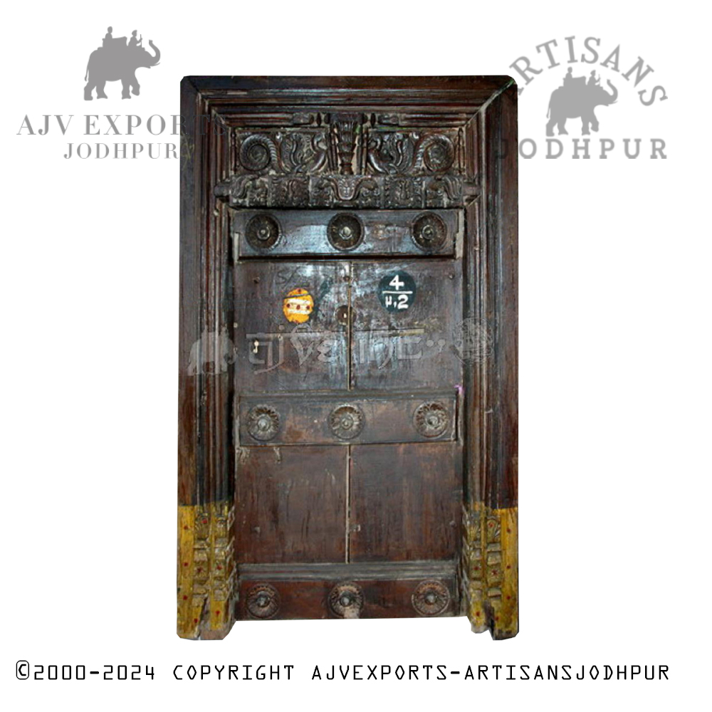A handcrafted wooden door with metal studs and intricate carvings.