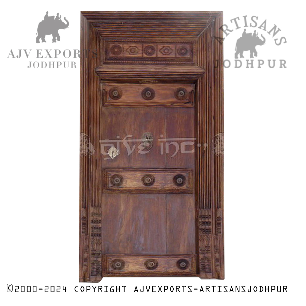 Rustic wooden door with a carved floral design, highlighting Jodhpur craftsmanship.