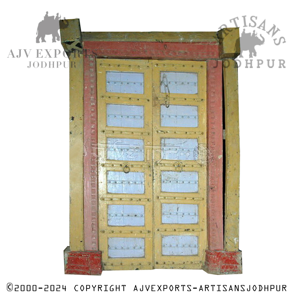 A vivid red and yellow painted wooden door with multiple  panels, surrounded by a rustic yellow frame, displaying a traditional and vintage appearance.