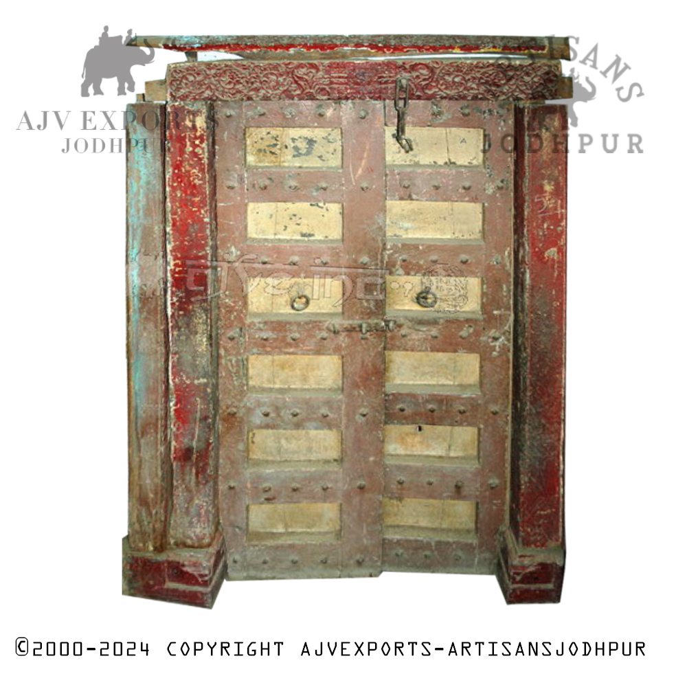 Distressed Indian door with faded paint and antique metal fittings.