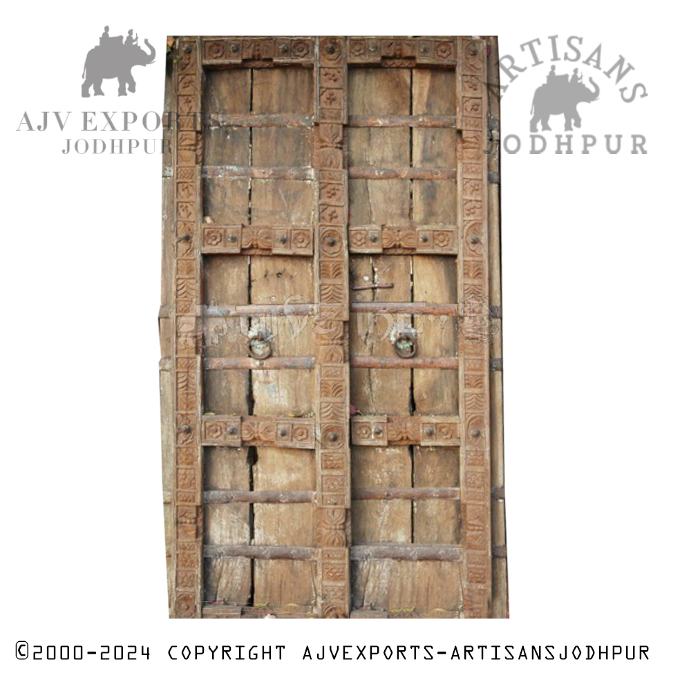 A rustic Indian barn door with heavy iron hardware and a robust wooden frame.