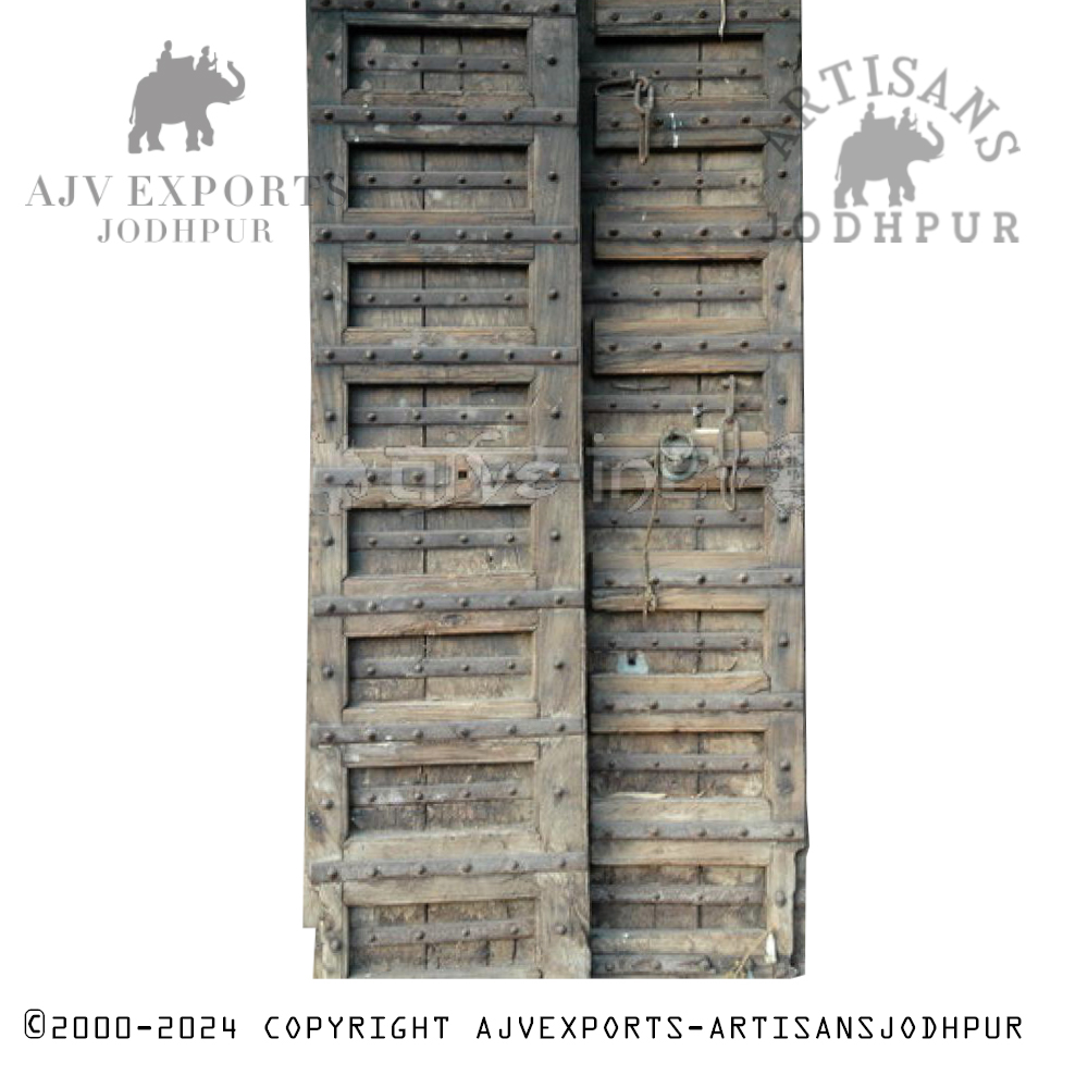 Heavy wooden fortress door from India, reinforced with metal studs and bands for added security.