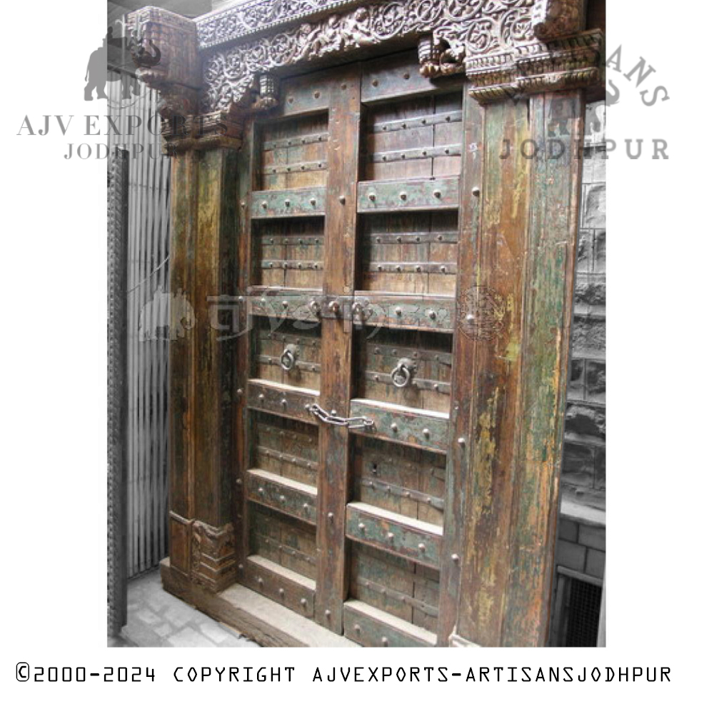 Antique Indian door with detailed ornamental carvings and vintage iron fittings.