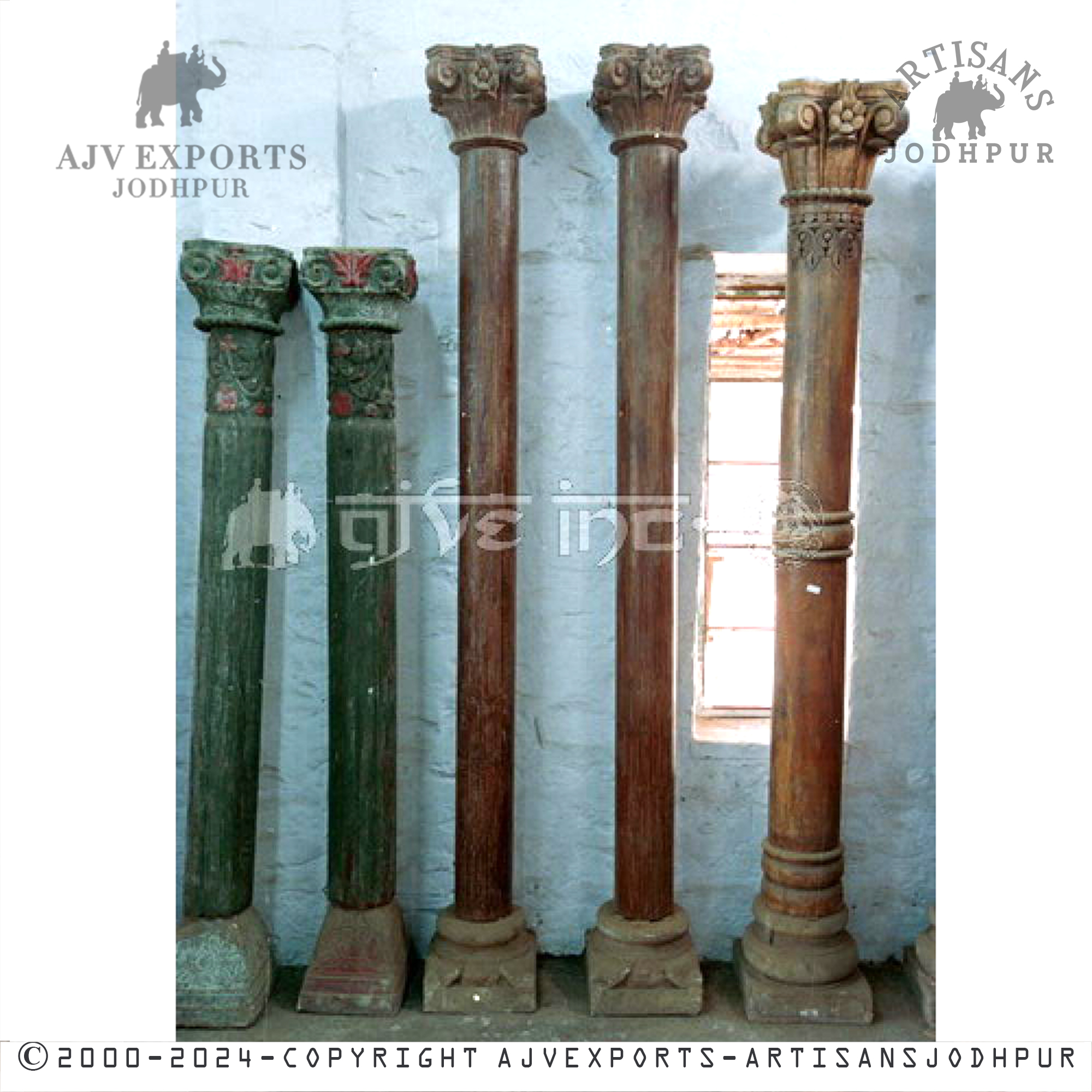 Two ornamental green columns with intricate carvings and decorative tops, embodying traditional craftsmanship.