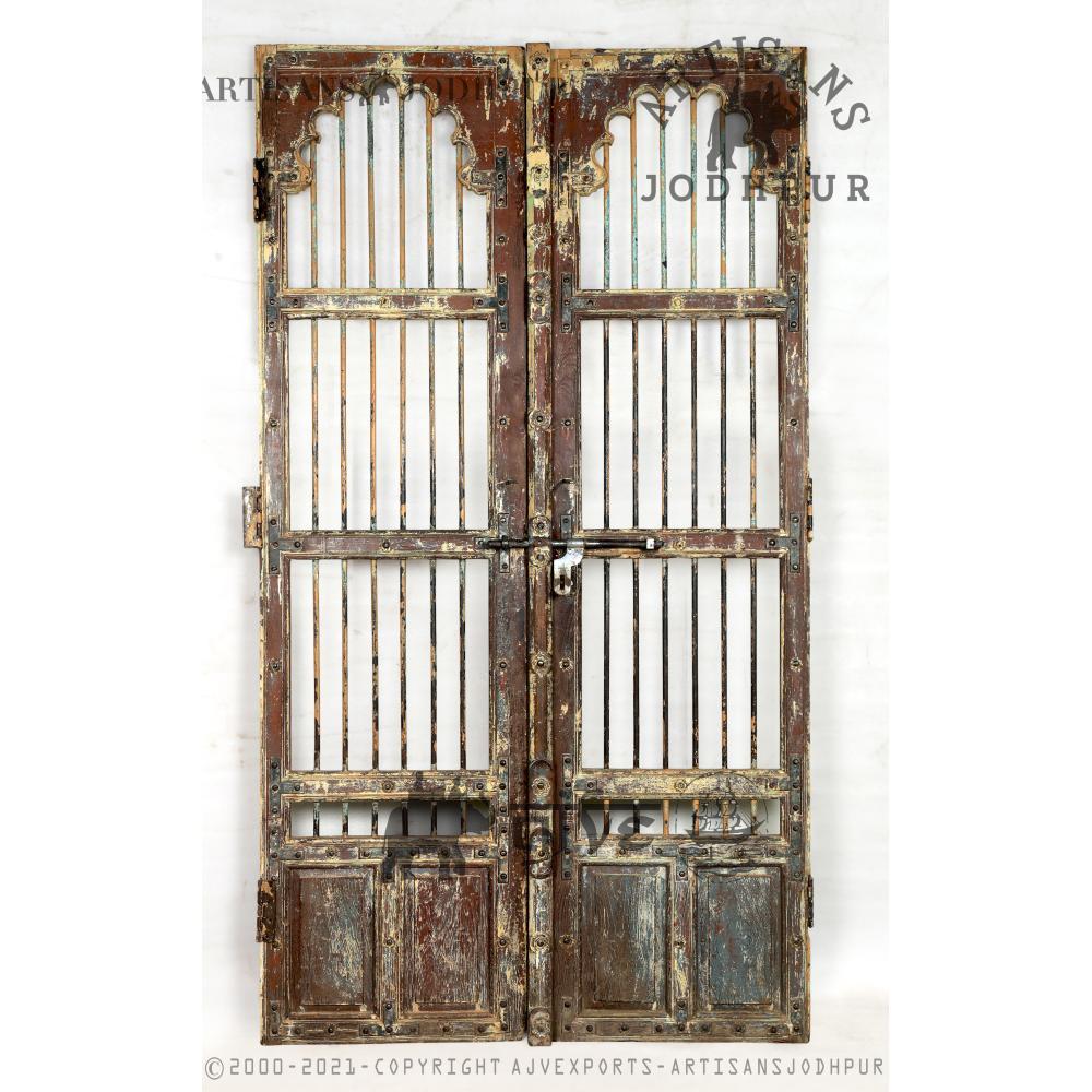 Weathered wooden doors with vertical iron bars