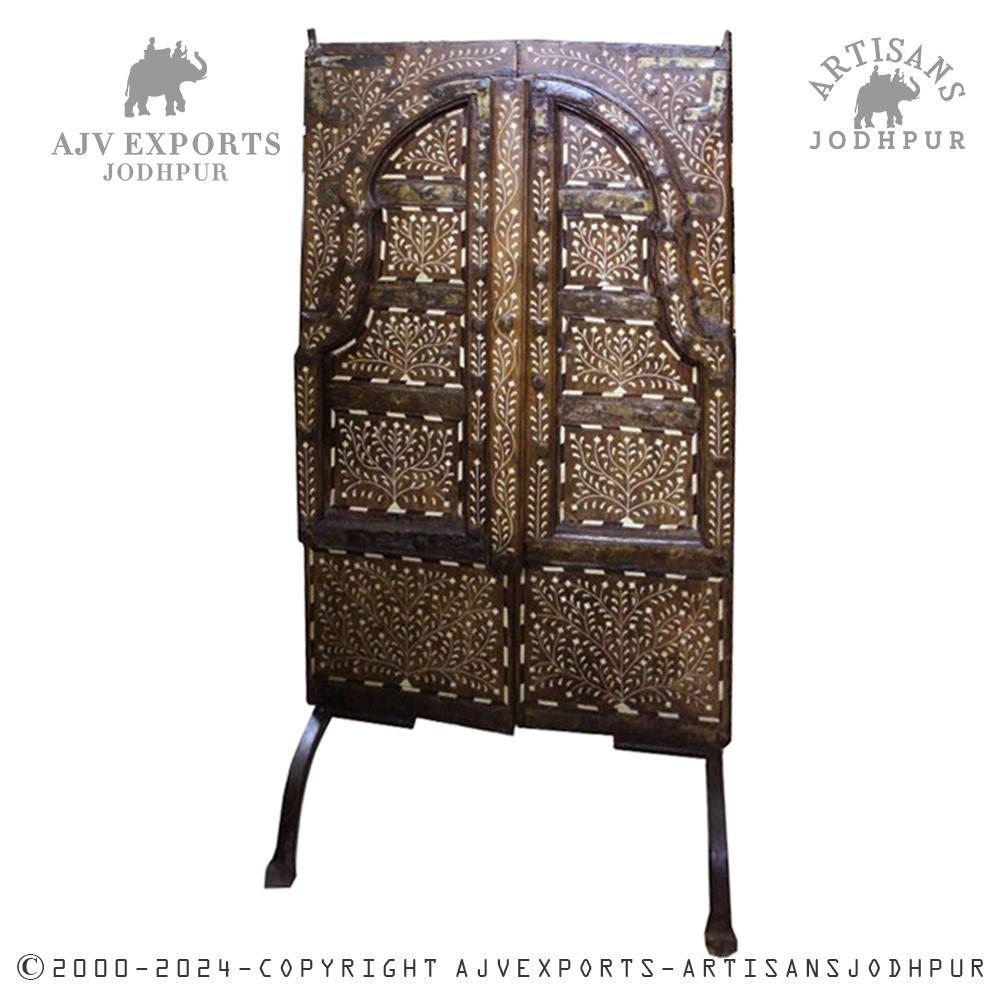 Intricately carved wooden door with inlay work and arched panels