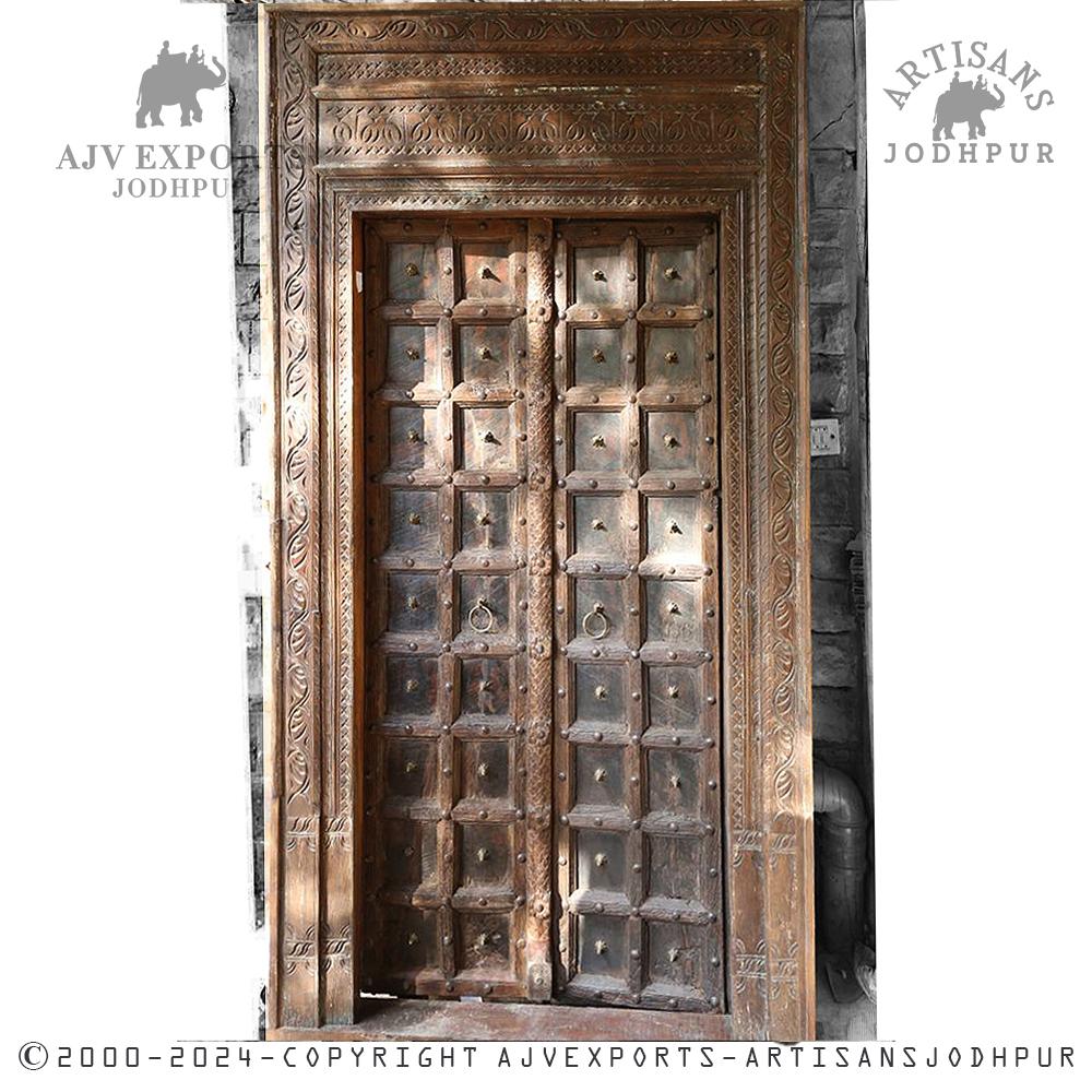 Antique wooden door with a heavily carved frame