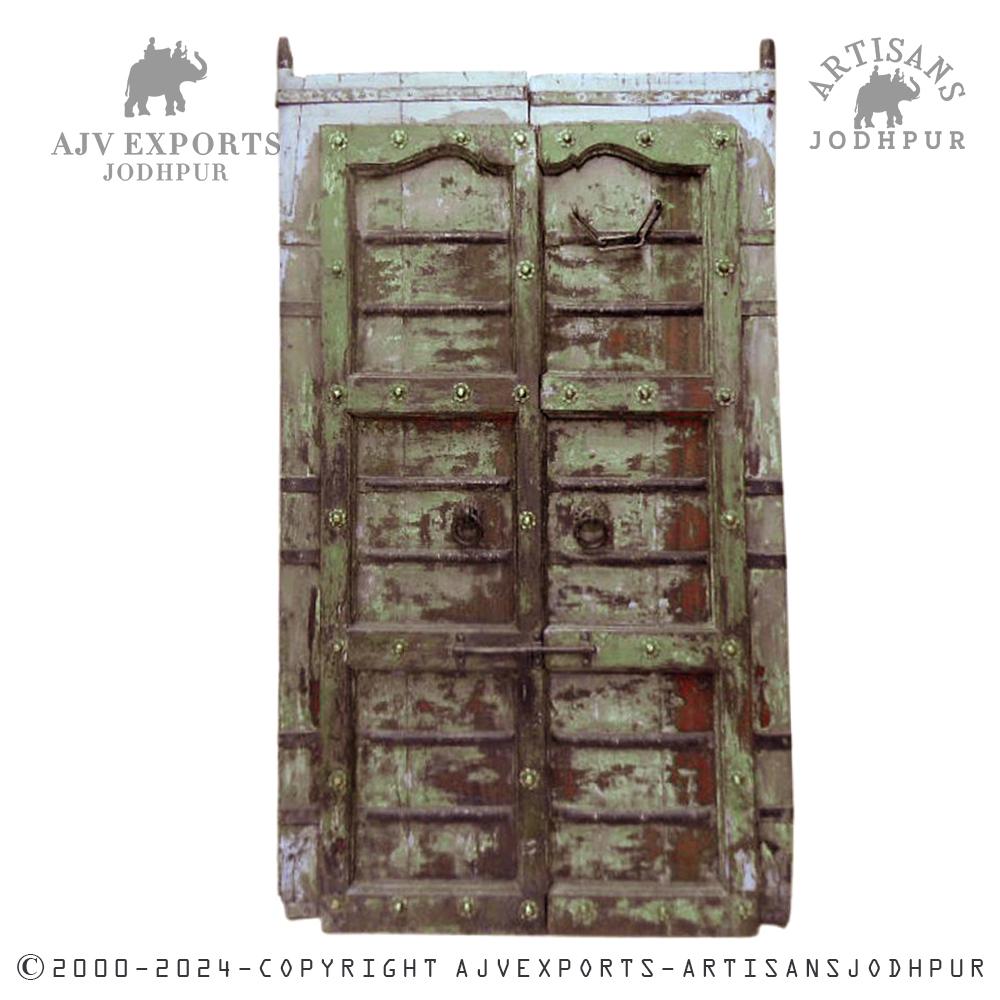 Green wooden door with distressed finish and metal accents