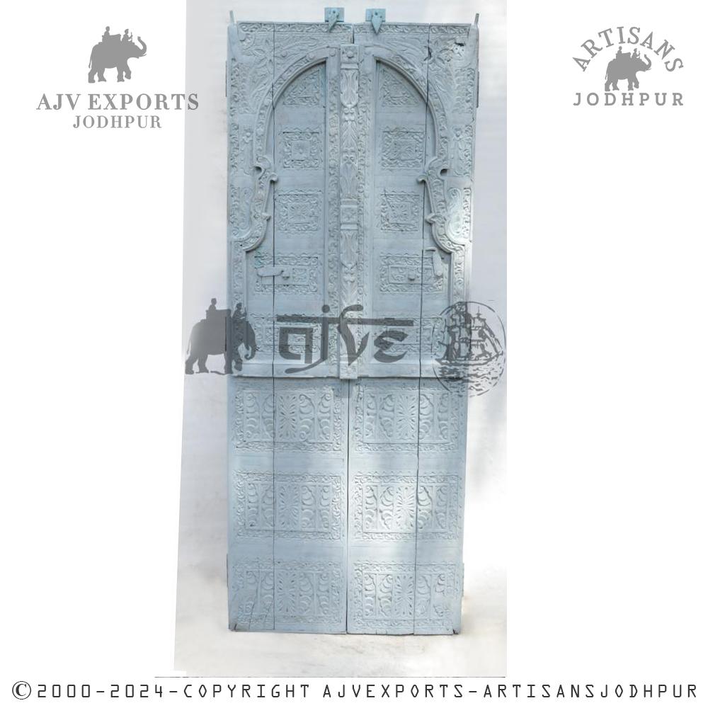 White wooden door with intricate carvings and arched panels