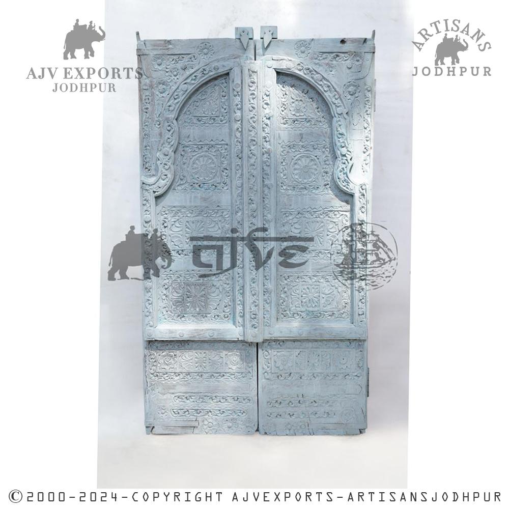 White carved wooden door with double arches and detailed carvings