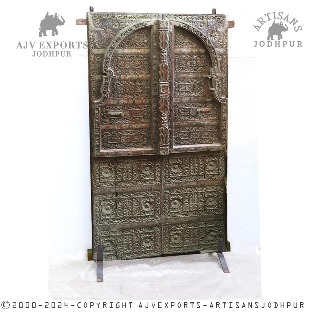 Ornate carved wooden door with iron accents and intricate patterns.