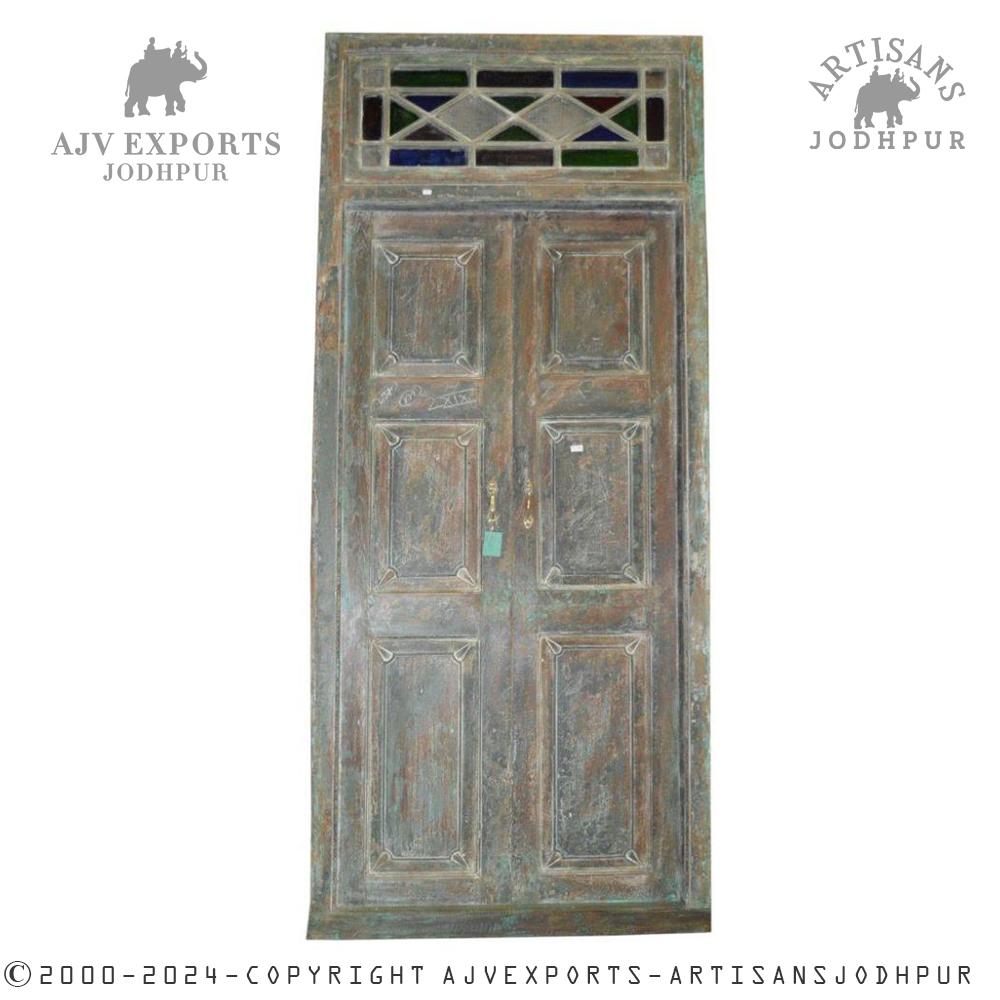 Traditional wooden door with glass panels and intricate wooden detailing.