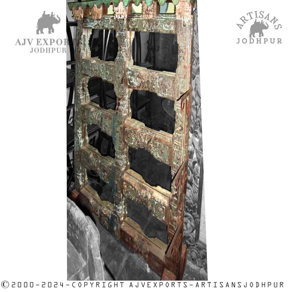A detailed view of an antique wooden door with ornate carvings, emphasizing traditional Indian architectural design.