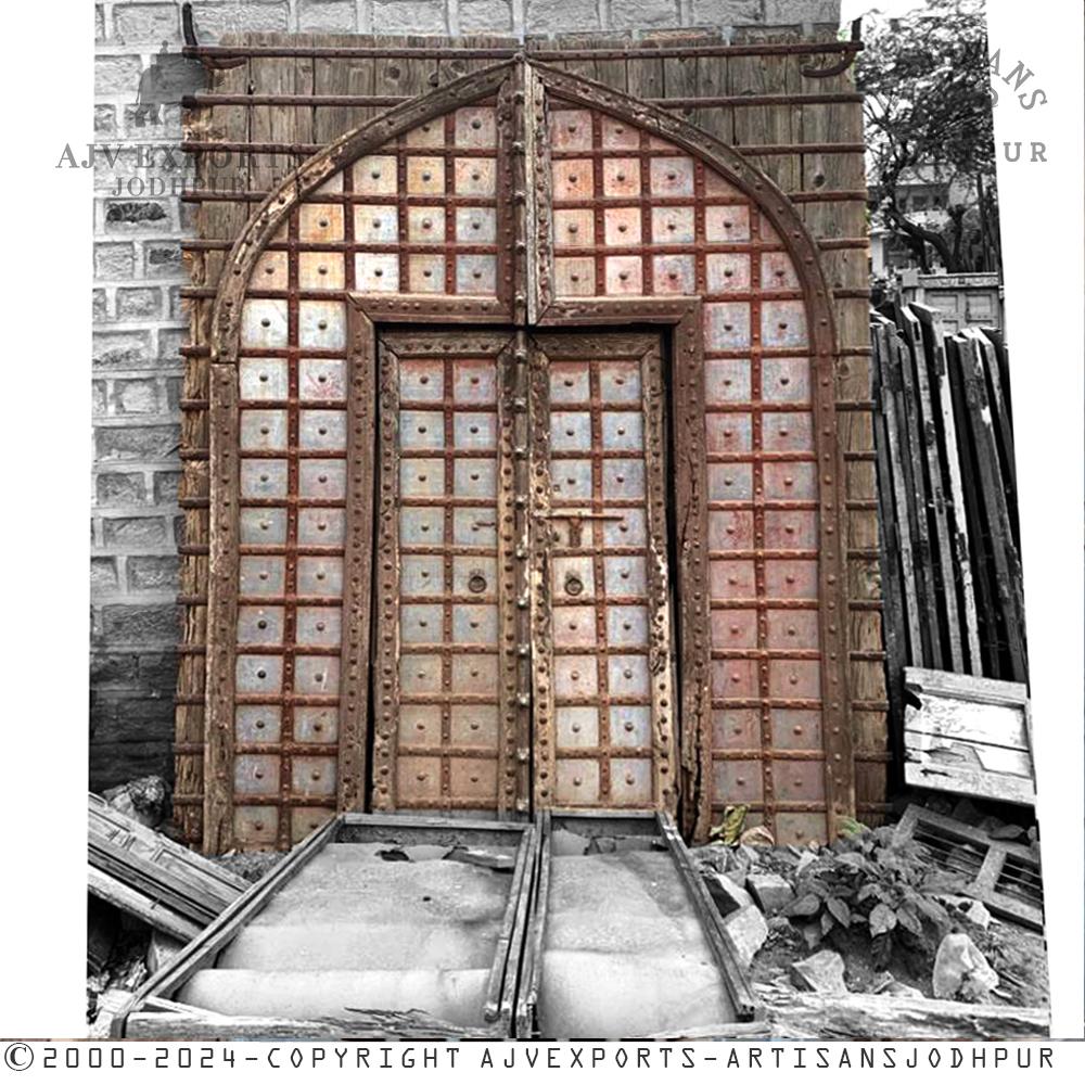 A vibrant arched metal door with colorful panels, reflecting a fusion of traditional Indian and artistic styles.